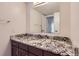 Bathroom with granite counters and a large mirror reflecting an open doorway at 6470 S Dayton St # K12, Englewood, CO 80111