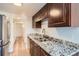 Renovated kitchen featuring granite countertops, stainless steel appliances, and dark wood cabinetry at 6470 S Dayton St # K12, Englewood, CO 80111