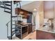 Modern kitchen with stainless steel appliances, granite countertops, dark wood cabinets and spiral staircase at 6470 S Dayton St # K12, Englewood, CO 80111