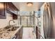 Modern kitchen with stainless steel appliances, granite countertops, dark wood cabinets, and a spiral staircase at 6470 S Dayton St # K12, Englewood, CO 80111