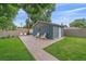 Backyard featuring a patio with outdoor seating, storage shed, lush green grass and mature trees at 4320 Teller St, Wheat Ridge, CO 80033