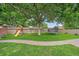 Spacious backyard with mature trees, lush green grass, play structure and trampoline at 4320 Teller St, Wheat Ridge, CO 80033