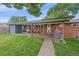 Exterior view of a backyard brick patio with a covered seating area, grill and grass at 4320 Teller St, Wheat Ridge, CO 80033