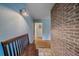 Inviting entryway with a wooden bench, brick accent wall, and hardwood floors at 4320 Teller St, Wheat Ridge, CO 80033