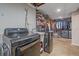 Laundry room with modern washer and dryer, utility sink, closet and open shelving at 4320 Teller St, Wheat Ridge, CO 80033