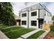 Contemporary two-story home with a well-manicured lawn, modern architectural details, and a rooftop deck at 1543 Glencoe St, Denver, CO 80220