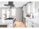 Contemporary kitchen with stainless steel appliances, an island cooktop, modern fixtures, and white cabinetry at 1543 Glencoe St, Denver, CO 80220