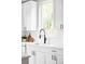 Close-up of kitchen featuring white cabinets, modern sink fixtures, and a bright window view at 1543 Glencoe St, Denver, CO 80220