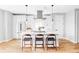 Bright kitchen with a center island, stylish stools, stainless steel appliances, and sleek white cabinets at 1543 Glencoe St, Denver, CO 80220