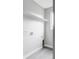 A bright laundry room with gray flooring, crisp white walls, shelving and appliances connections at 1543 Glencoe St, Denver, CO 80220