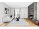 Inviting living room with a modern fireplace, light hardwood floors, and neutral-toned furniture at 1543 Glencoe St, Denver, CO 80220