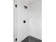 Modern walk-in shower with black accents, white tiled walls, and clear glass doors at 1543 Glencoe St, Denver, CO 80220