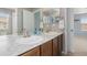 Bathroom featuring dual sinks, a spacious countertop, and access to both the shower and a bedroom at 2510 E 160Th Pl, Thornton, CO 80602