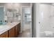 Bathroom with double sinks, a large mirror, wood cabinets, and access to a tub/shower combo at 2510 E 160Th Pl, Thornton, CO 80602