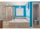 Bright bathroom featuring a soaking tub, walk-in shower, and vibrant turquoise walls at 2510 E 160Th Pl, Thornton, CO 80602