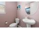 Charming powder room featuring a pedestal sink, toilet, and coastal decor, creating a refreshing space at 2510 E 160Th Pl, Thornton, CO 80602
