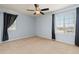 Bedroom with two windows, neutral carpet, and modern ceiling fan, offering a simple and comfortable space at 2510 E 160Th Pl, Thornton, CO 80602