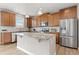 Spacious kitchen featuring granite countertops, stainless steel appliances, island, and wood cabinets at 2510 E 160Th Pl, Thornton, CO 80602