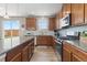 Modern kitchen featuring wooden cabinets, granite countertops, stainless steel appliances, and a large island at 2510 E 160Th Pl, Thornton, CO 80602