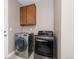Modern laundry room with front-loading washer and dryer, and upper cabinets for storage at 2510 E 160Th Pl, Thornton, CO 80602