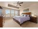 Bright main bedroom featuring tray ceilings, a ceiling fan, and large windows for ample natural light at 2510 E 160Th Pl, Thornton, CO 80602