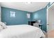 Bedroom with a blue accent wall, a white comforter, and a desk area at 4419 N Quatar Ct, Aurora, CO 80019