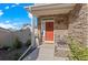 Inviting front porch featuring a red door, stone accents and a cozy seating area at 4419 N Quatar Ct, Aurora, CO 80019