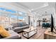 Open-concept living room and kitchen with large windows, hardwood floors, and modern decor at 4419 N Quatar Ct, Aurora, CO 80019