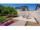 Secluded backyard featuring a white fence, mature trees, gravel accents, and a concrete patio with chairs at 5659 Viewpoint Ave, Firestone, CO 80504