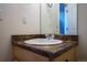 Bathroom sink with modern faucet, light wood cabinet and a clear mirror over a light colored countertop at 5659 Viewpoint Ave, Firestone, CO 80504