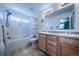 Bright bathroom featuring dual sinks, a large mirror, a bathtub with shower, and light-colored tile floors at 5659 Viewpoint Ave, Firestone, CO 80504