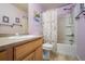 Cozy bathroom featuring a shower-tub combo with a patterned shower curtain and a wood-look vanity at 5659 Viewpoint Ave, Firestone, CO 80504