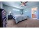 Comfortable bedroom with a ceiling fan, light colored walls and carpet, and a black dresser at 5659 Viewpoint Ave, Firestone, CO 80504
