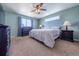 Comfortable bedroom with a ceiling fan, light colored walls and carpet, and a black dresser at 5659 Viewpoint Ave, Firestone, CO 80504