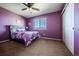 Cozy bedroom with purple walls, a ceiling fan, and natural light from the window at 5659 Viewpoint Ave, Firestone, CO 80504