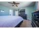 Cozy bedroom with a ceiling fan, light colored walls and carpet, and a black dresser with TV at 5659 Viewpoint Ave, Firestone, CO 80504