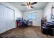Functional bedroom featuring plush carpet, a ceiling fan, a large window, and ample space for a desk at 5659 Viewpoint Ave, Firestone, CO 80504