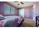 Comfortable bedroom featuring a ceiling fan, neutral carpet, and a bright window with wood-look blinds at 5659 Viewpoint Ave, Firestone, CO 80504