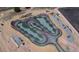 Aerial view of pump track with red accents, gray gravel and grassy areas, near wooden ramps and a blue shelter at 5659 Viewpoint Ave, Firestone, CO 80504