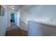 Bright hallway with carpet and stairs, with railing overlooking the home below and a peek into a bedroom at 5659 Viewpoint Ave, Firestone, CO 80504