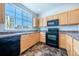 Modern kitchen with a window above the sink, ample cabinet space, and black appliances at 5659 Viewpoint Ave, Firestone, CO 80504