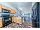 Open-concept kitchen with island, sleek appliances, and view into the dining area at 5659 Viewpoint Ave, Firestone, CO 80504