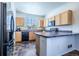 Well-lit kitchen with wooden cabinets, black appliances, and a corner island counter at 5659 Viewpoint Ave, Firestone, CO 80504