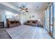 Spacious living room with dual couches, ceiling fan, stylish rug and lots of natural light from the sliding door at 5659 Viewpoint Ave, Firestone, CO 80504