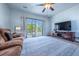 Bright living room with a sliding glass door leading to the yard, neutral walls, and carpet flooring at 5659 Viewpoint Ave, Firestone, CO 80504