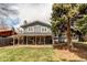 Charming gray two-story home showcasing a covered patio and a lush green lawn at 8370 E Princeton Ave, Denver, CO 80237