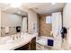 Bathroom showcasing a modern vanity, tub with shower, and neutral tile throughout at 8370 E Princeton Ave, Denver, CO 80237