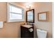 Bathroom sink vanity with a large mirror, light fixtures, and a window at 8370 E Princeton Ave, Denver, CO 80237