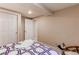 Cozy bedroom featuring white trim and neutral walls, accented with a patterned comforter on the bed at 8370 E Princeton Ave, Denver, CO 80237