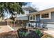 Exterior showcasing gray brick, well-maintained landscaping, garden beds, and covered patio at 8370 E Princeton Ave, Denver, CO 80237